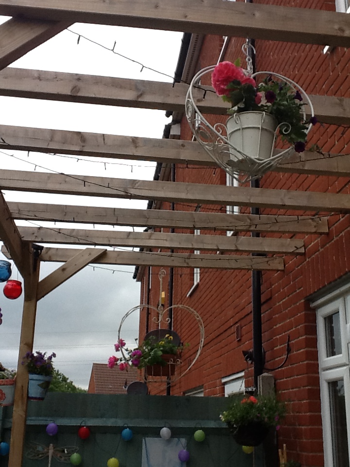 Pergola with hanging baskets in the garden