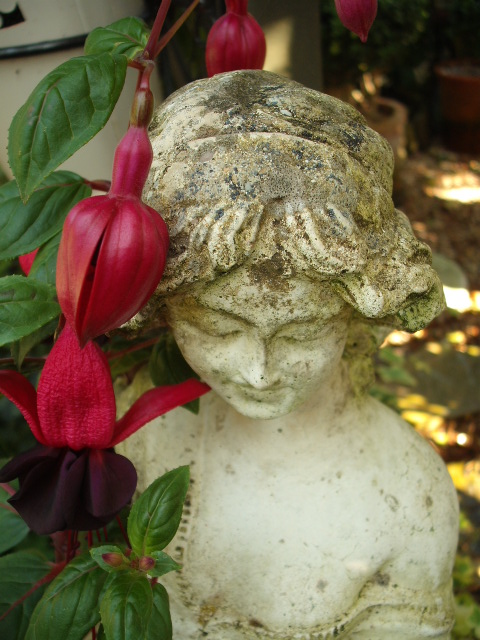 Statue resting under flowers in the garden