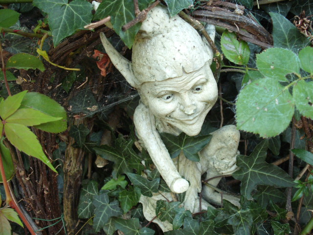 Broken gnome resting at the bottom of the garden