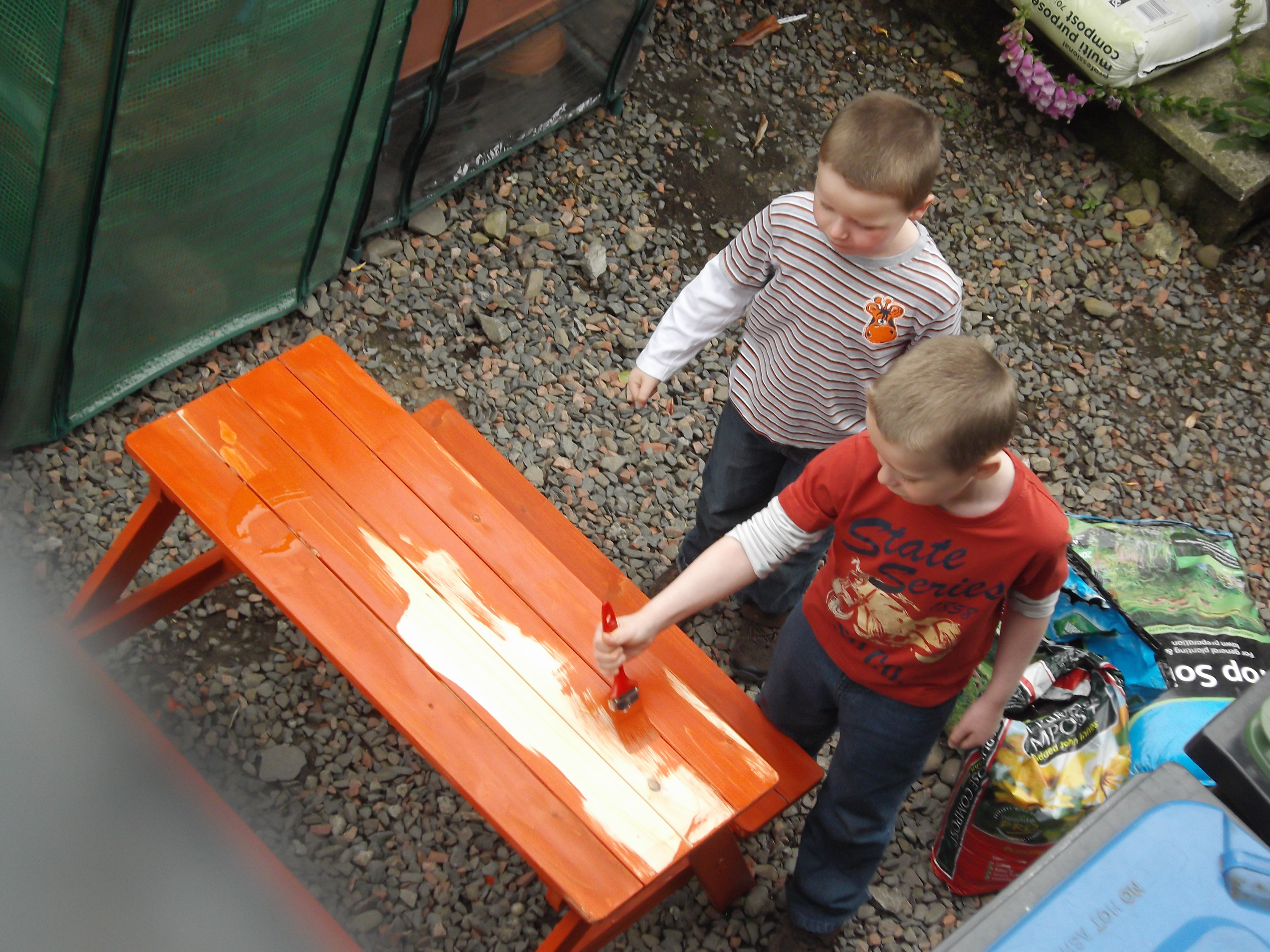 Boys weather-proofing the picnic bench